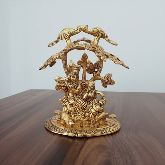 Gold-colored figurine on a wooden surface with a light gray background