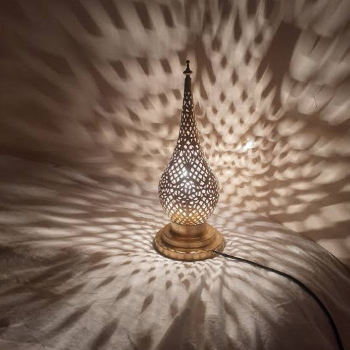Decorative lamp casting intricate shadows on a textured wall