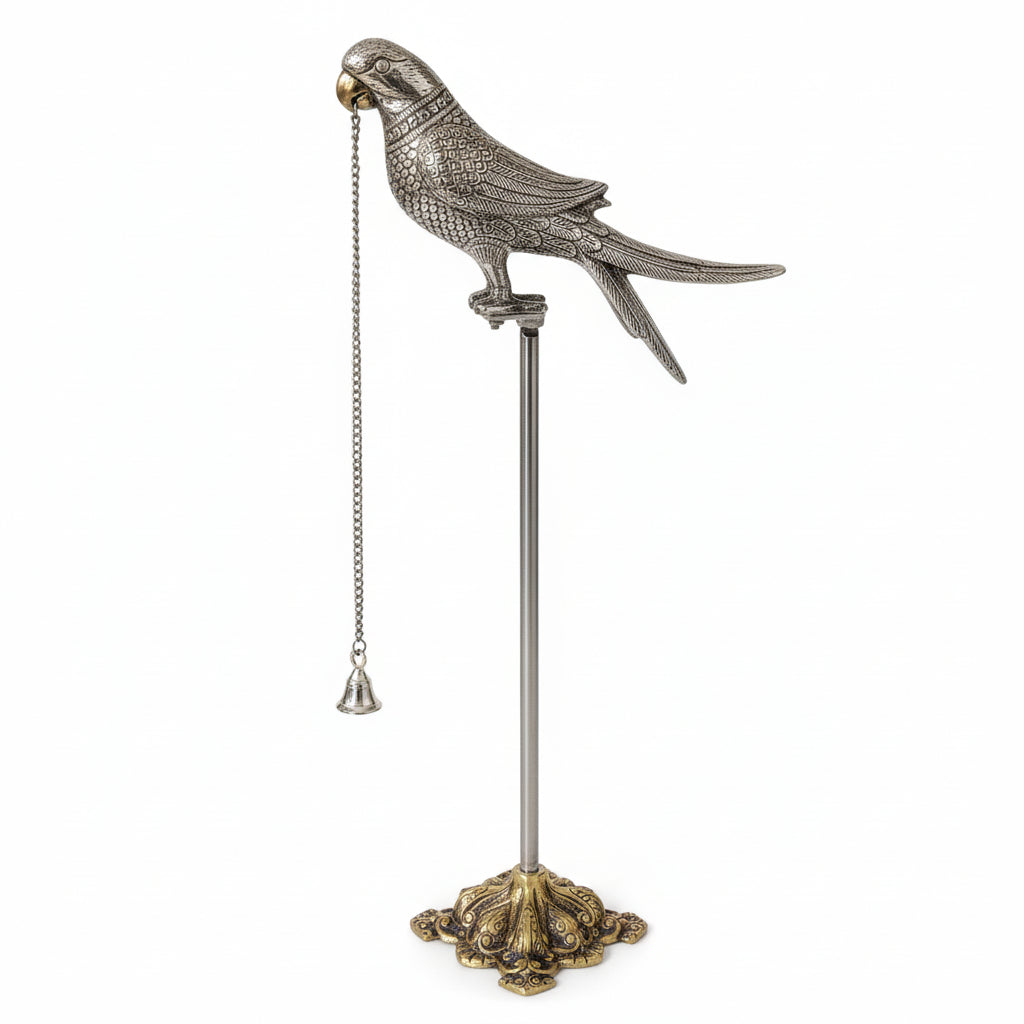 Silver parrot figurine on a stand with a chain, on a light gray background