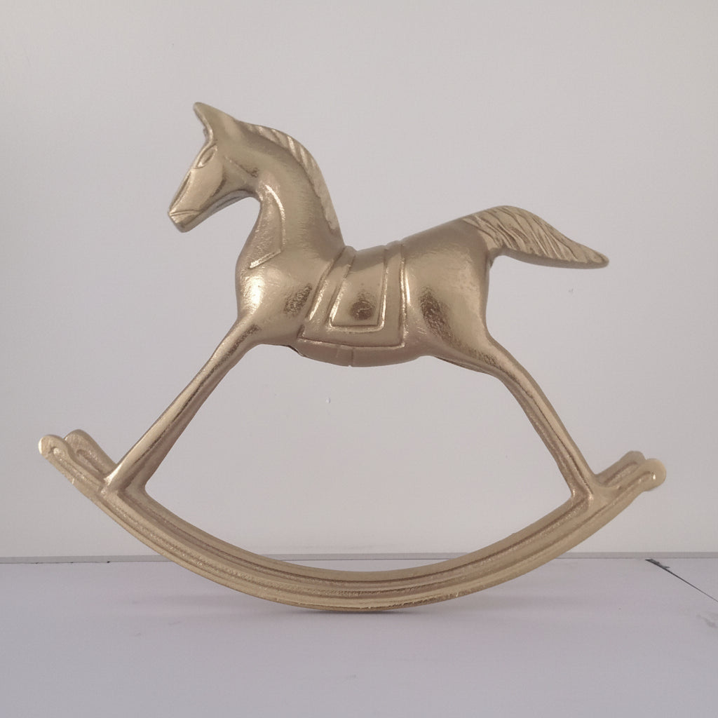 Brass rocking horse toy on a white background