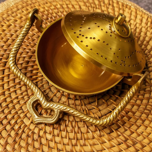 Brass tea infuser on a woven surface