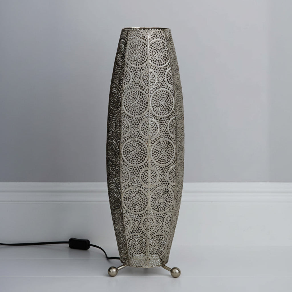 Decorative floor lamp with intricate design on a plain background