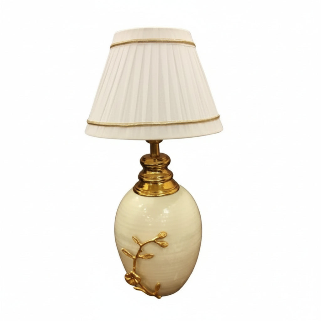 Decorative table lamp with a cream-colored base and pleated white shade on a white background