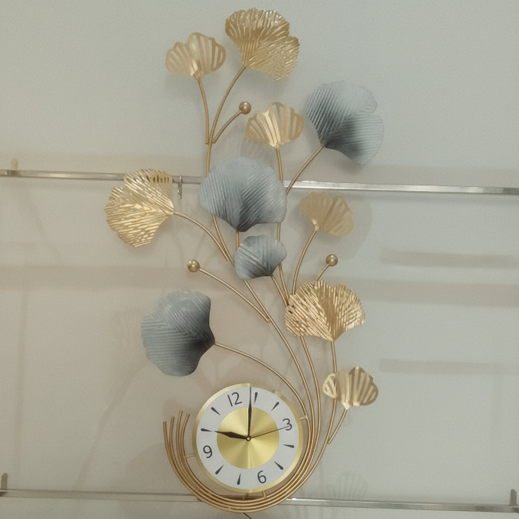 Decorative wall clock with gold leaf design on a light background