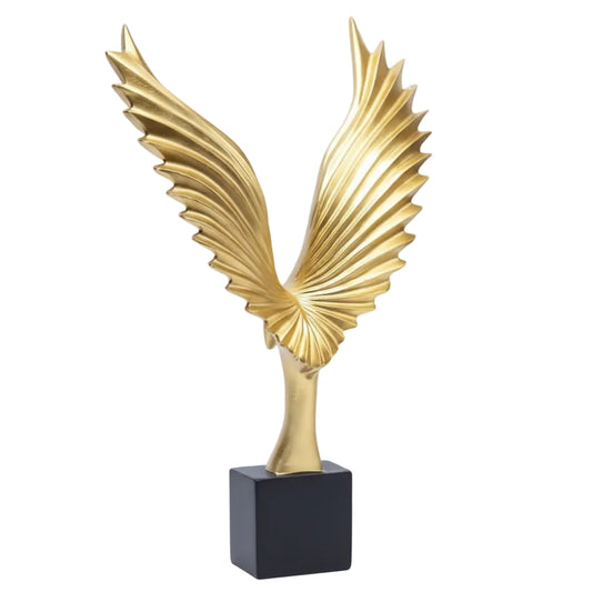 Gold winged sculpture on a white background
