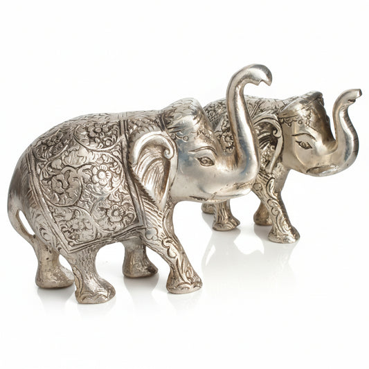 Decorative silver elephant figurine on a reflective surface