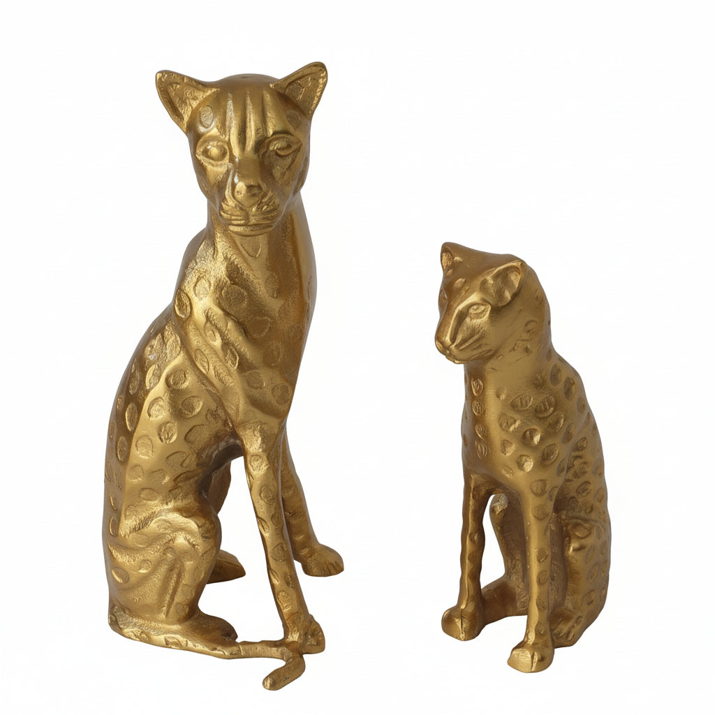 Two gold cat figurines on a marble surface