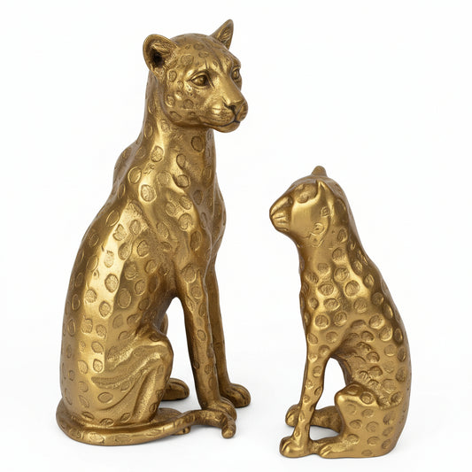 Two gold leopard statues on a white background
