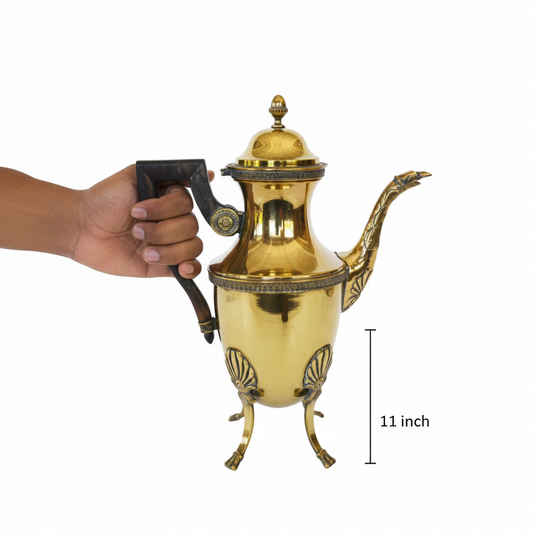 Gold teapot held by a hand with a measurement label indicating 11 inches on a white background