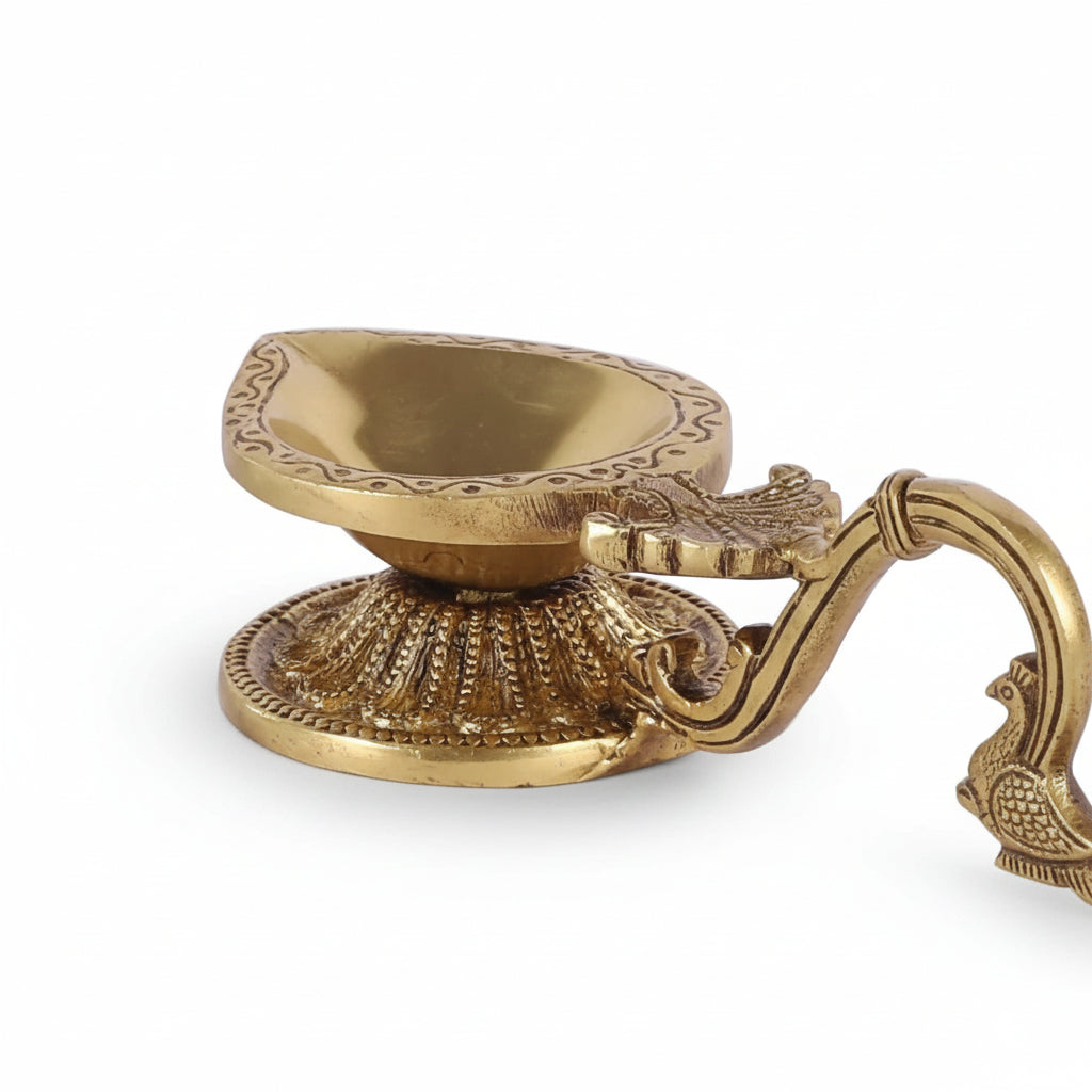 Brass oil lamp with intricate design on a white background