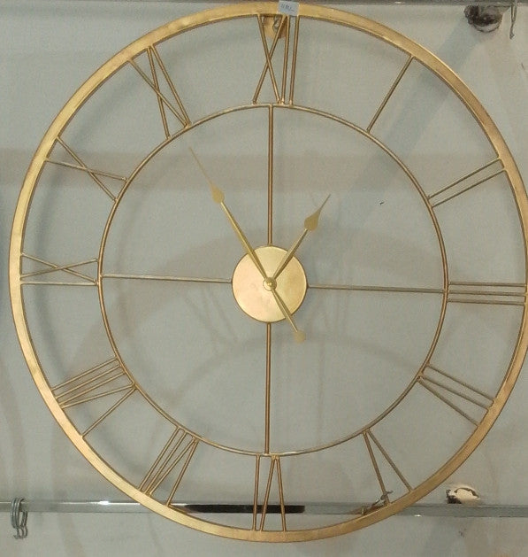 Gold wall clock with Roman numerals on a light background