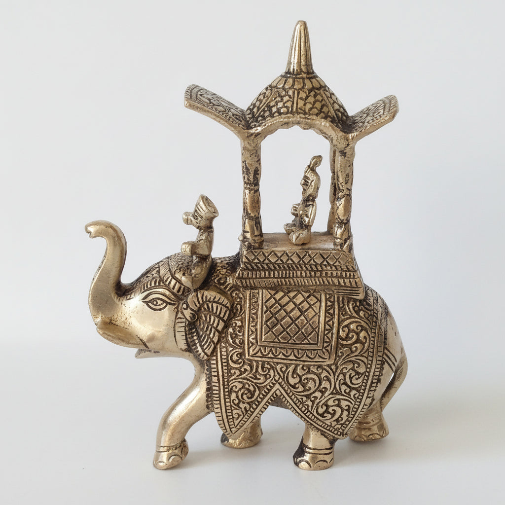 Decorative brass elephant figurine with intricate designs on a plain background