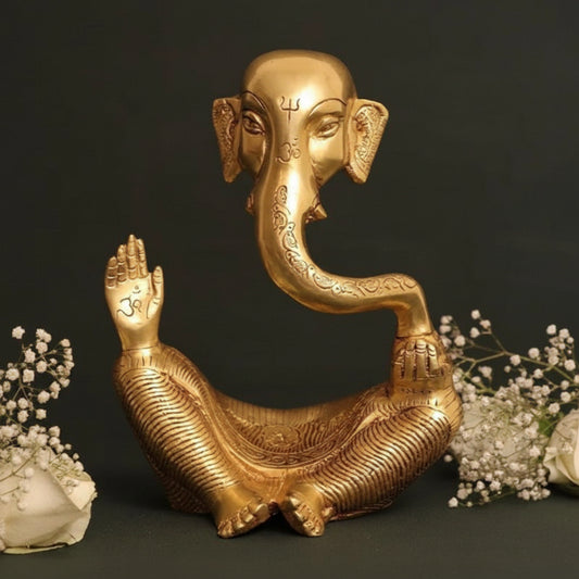 Gold elephant statue with floral decorations on a dark background
