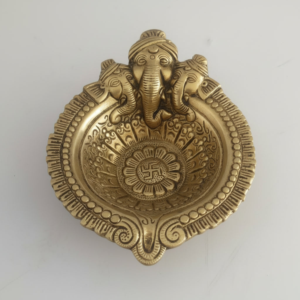 Decorative brass plaque with elephant design and swastika symbol on a white background