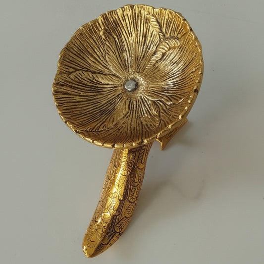 Decorative gold mushroom-shaped object on a light gray background