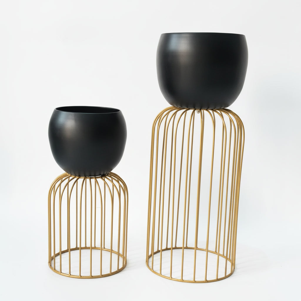 Two black planters on gold wire stands against a white background