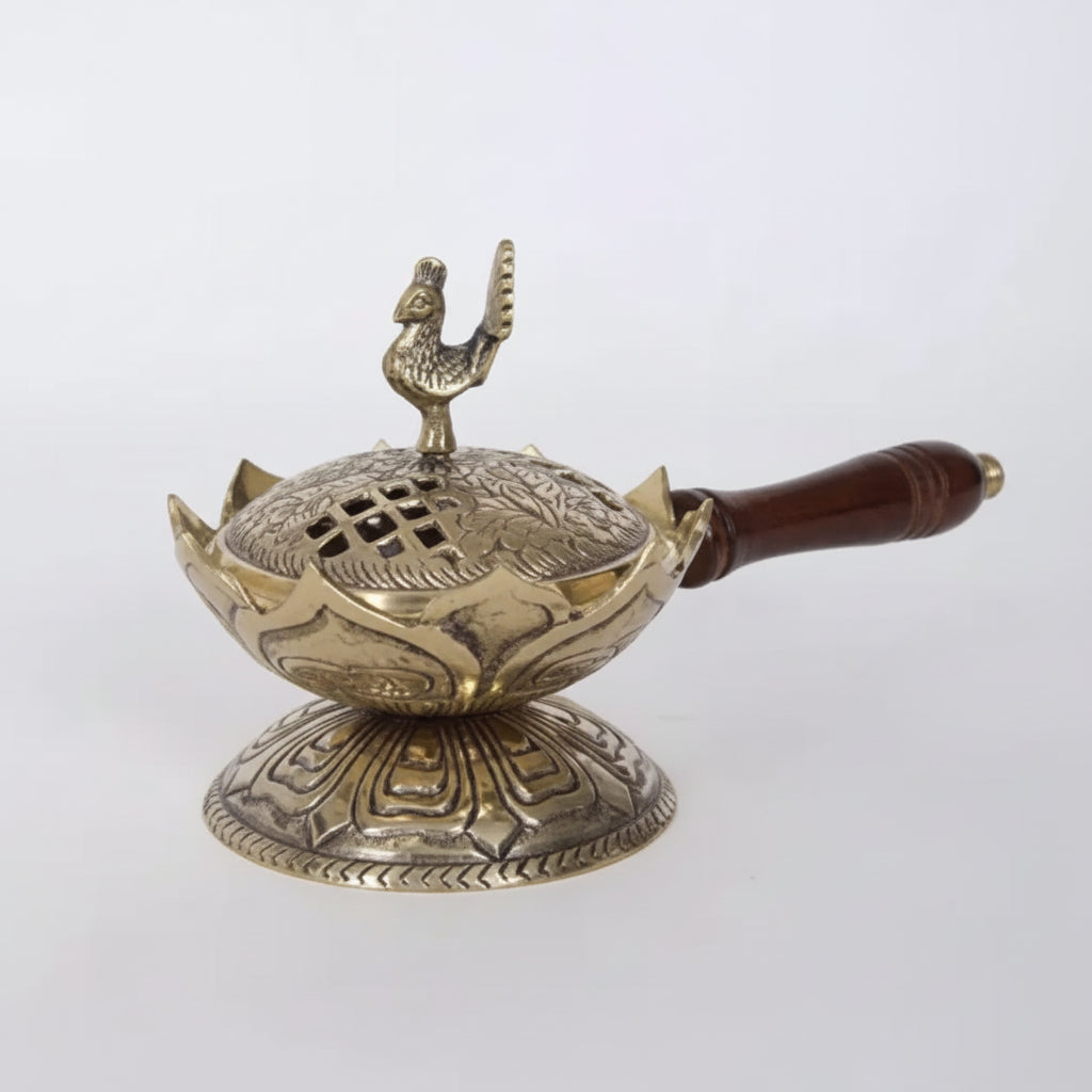 Decorative brass incense holder with wooden handle on a white background