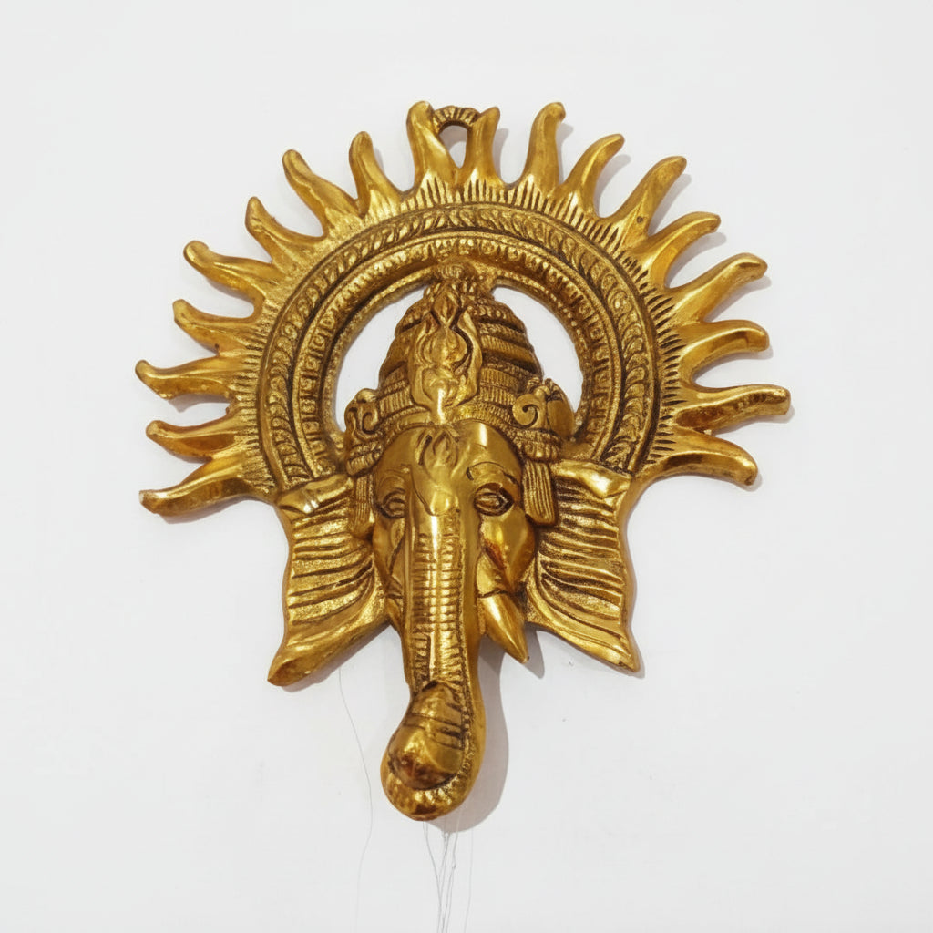 Decorative gold emblem with a sun design and elephant head on a white background
