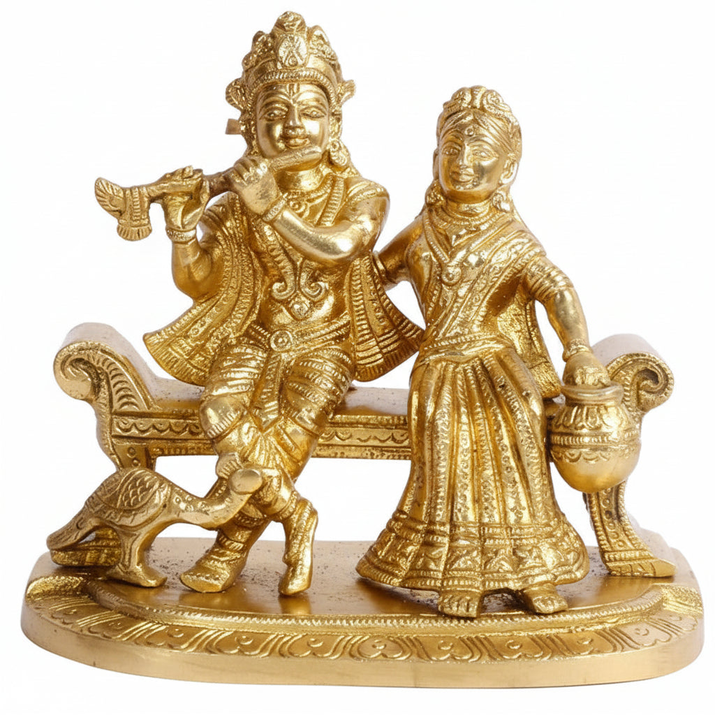 Gold-colored statue of a seated figure with a standing figure holding a pot on a white background