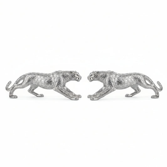 Silver panther statue on a white surface with a neutral background