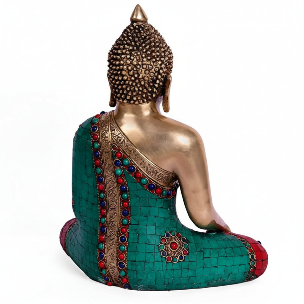 Decorative Buddha statue with teal robe and colorful embellishments on a white background