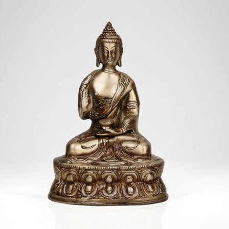 Bronze statue of a seated Buddha on a white background