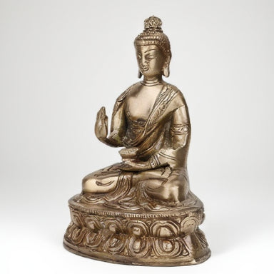 Bronze statue of a seated Buddha on a white background