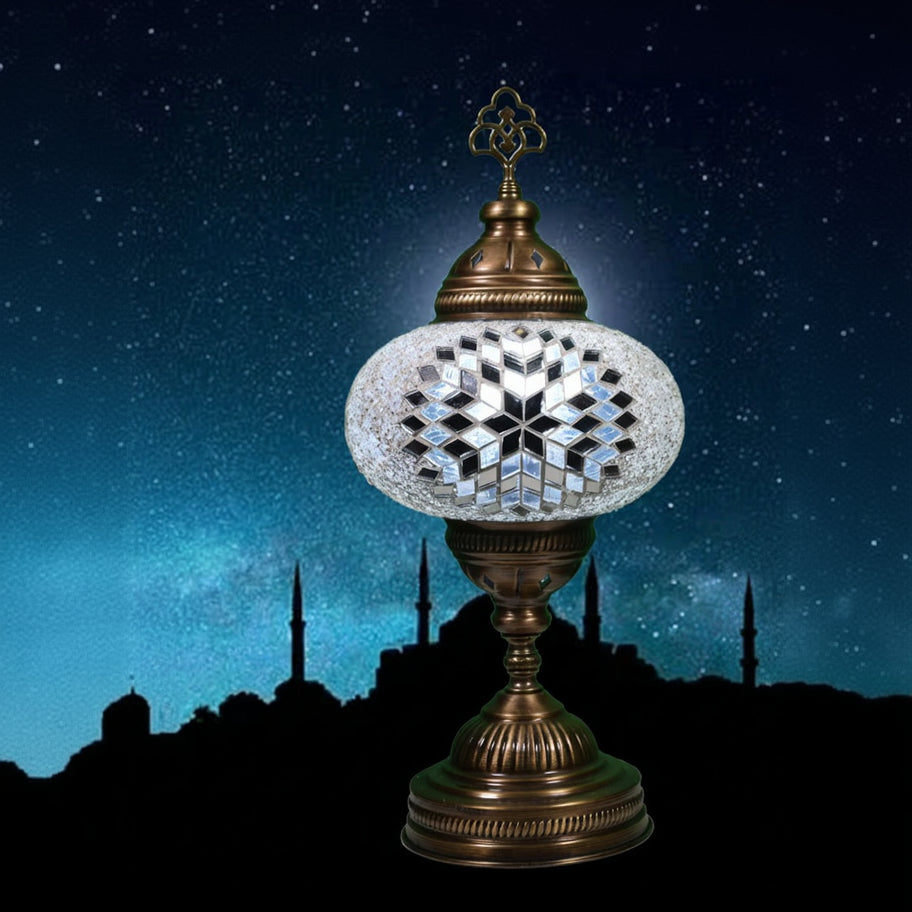 Decorative lamp with intricate design against a night sky silhouette