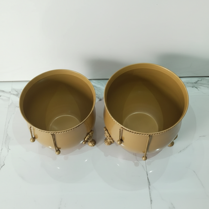 Two gold decorative containers on a marble surface