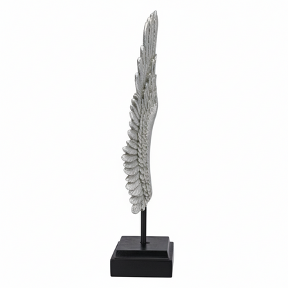 Decorative feather sculpture on a black base against a white background
