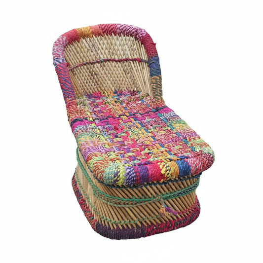 Woven chair with colorful fabric cover on a stone pavement