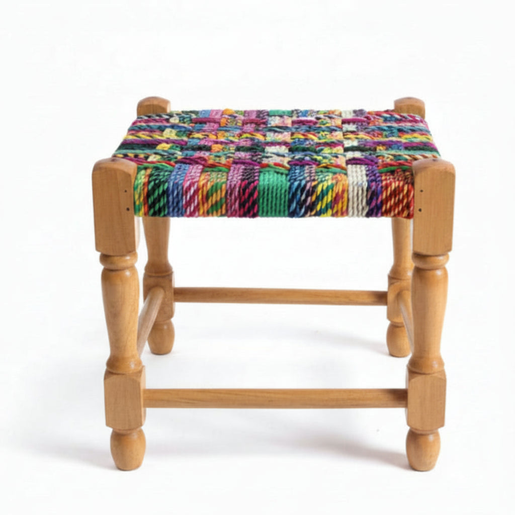 Wooden stool with a colorful woven seat on a marble floor.