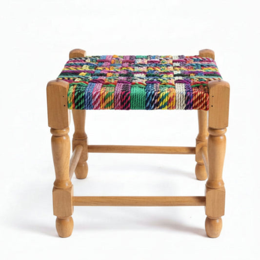 Wooden stool with a colorful woven seat on a marble floor.