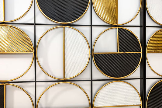 Decorative wall art with geometric circular patterns in black, gold, and white.