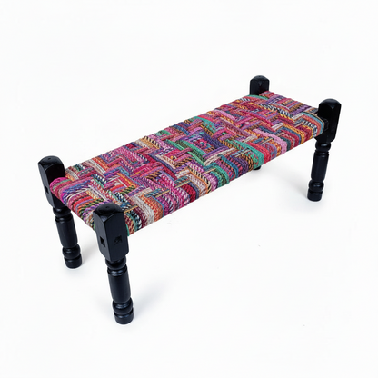 Colorful woven bench with black wooden legs on a white background
