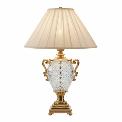 Decorative table lamp with crystal base and pleated beige shade on a black background