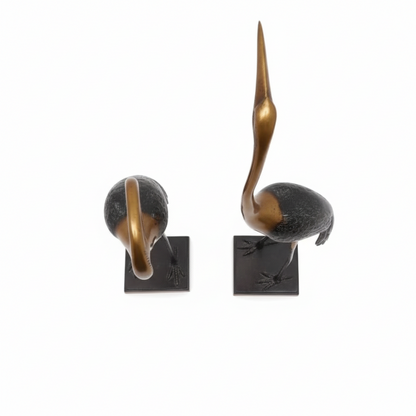 Two bronze sculptures of birds on a white background