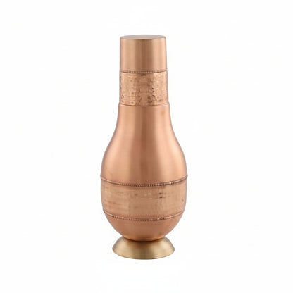 Copper vase with textured design on a light gray background