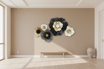 Decorative wall art with floral designs in black, gold, and white on a light gray background.