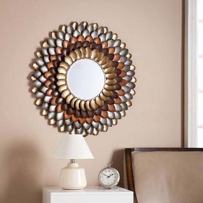 Decorative wall mirror with a floral pattern on a beige wall.