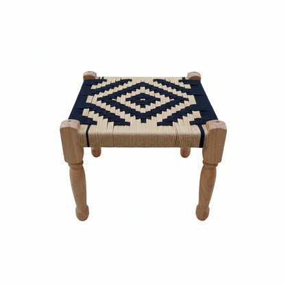 Small stool with woven top and wooden legs on a gray pavement