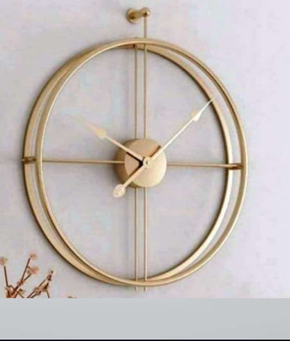 Gold wall clock with a decorative design on a light background