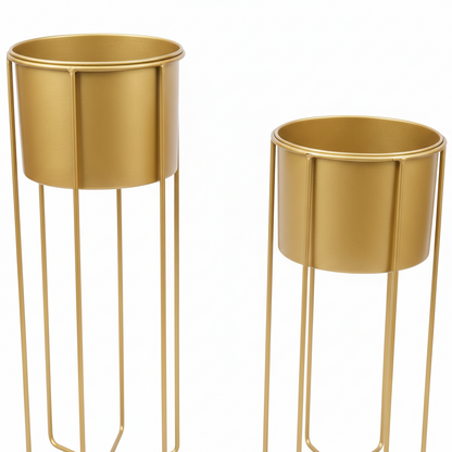Two gold metal planters with stands on a white background