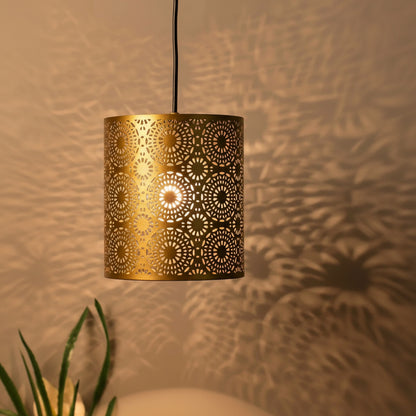 Decorative pendant light with intricate cut-out design on a neutral background