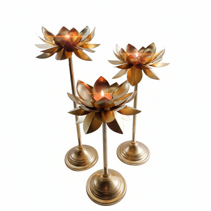 Three gold lotus flower candle holders on a white background