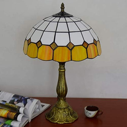 Tiffany-style table lamp with stained glass shade on a wooden surface.