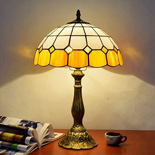 Tiffany-style table lamp with stained glass shade on a wooden surface.