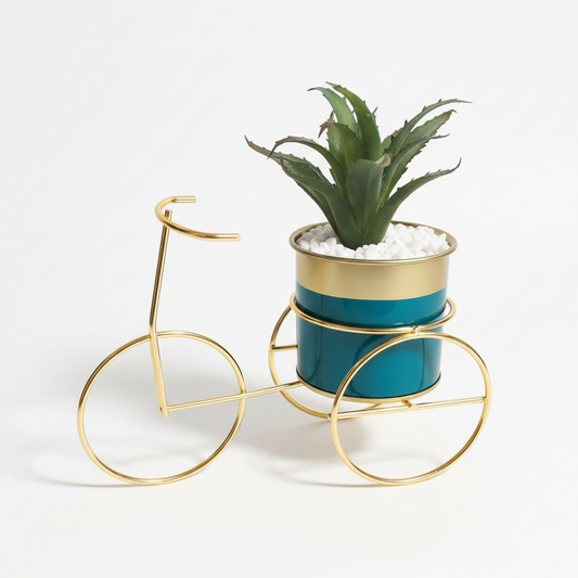 Potted plant in a decorative gold bike stand on a textured white surface