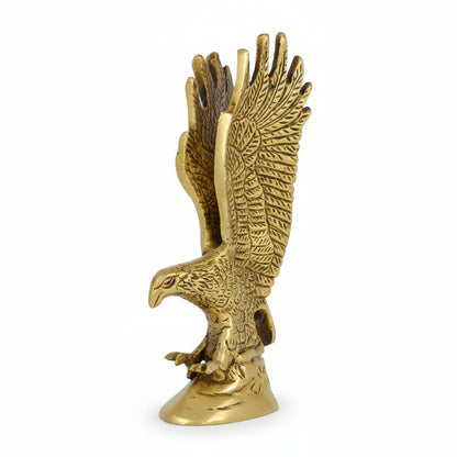 Gold eagle statue on a wooden surface with a marble background