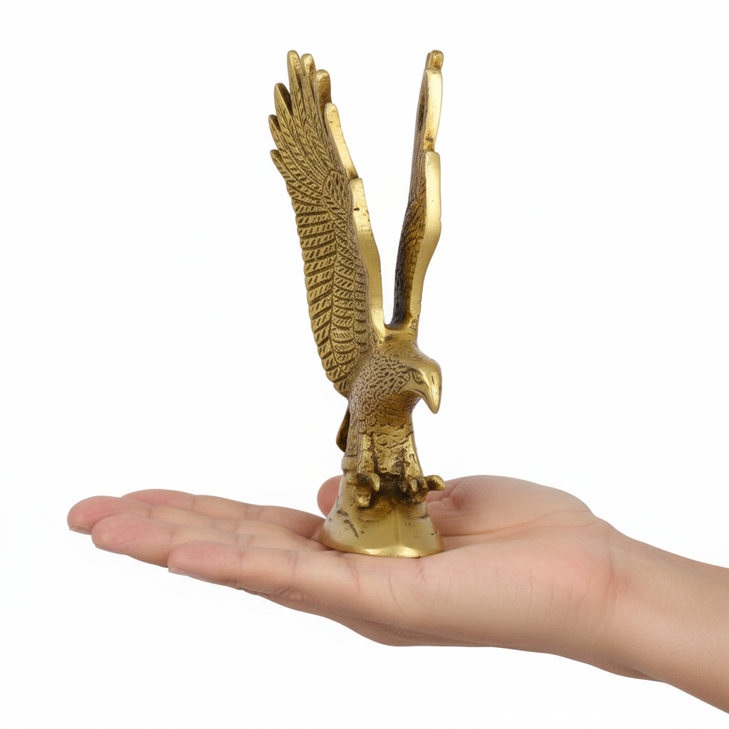 Gold eagle statue held in a hand against a white background